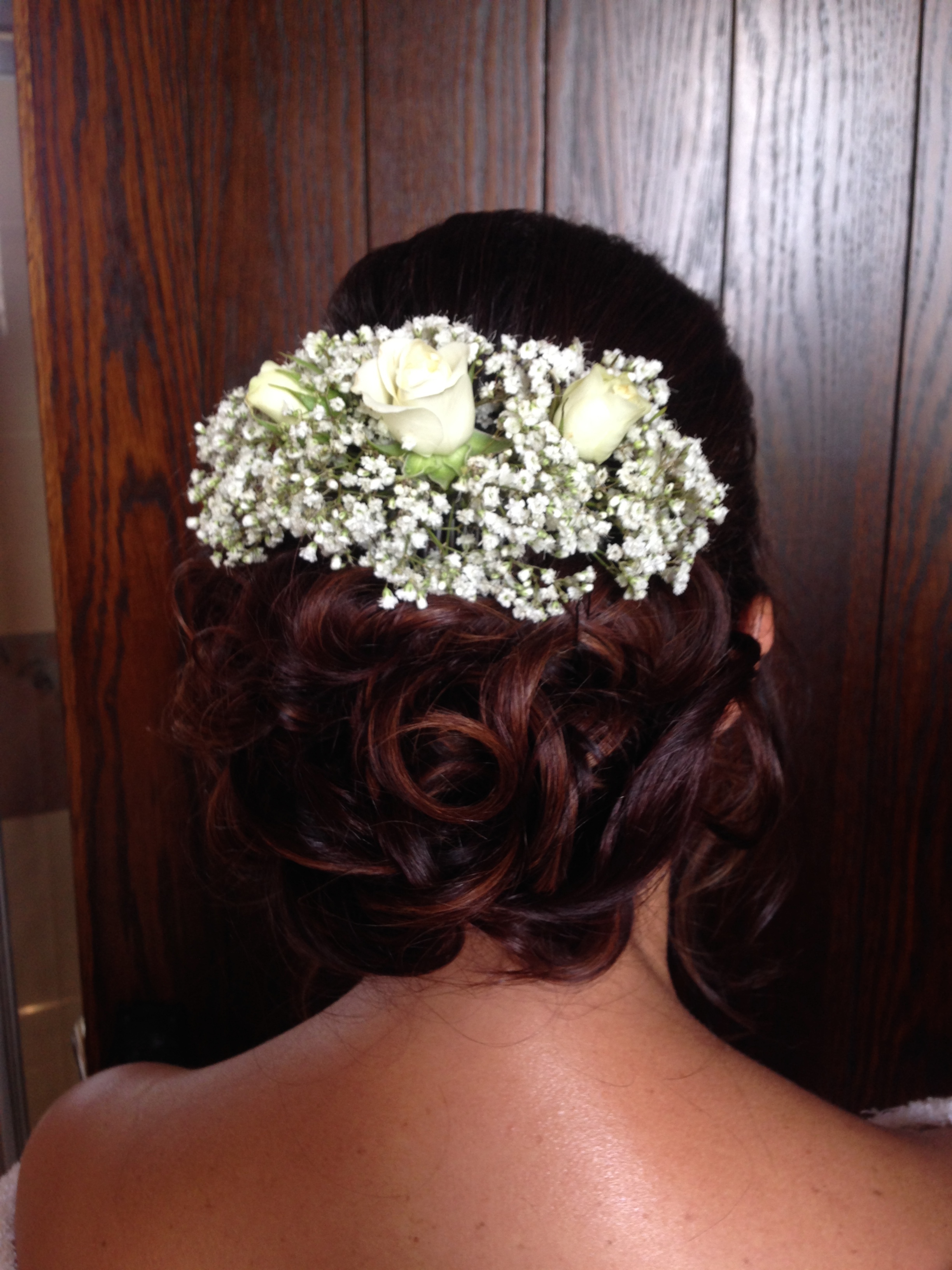 Curled bridal bun hairstyle with natural flowers